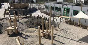 Betonnen schoolplein na transformatie veranderd in speelomgeving vol natuur